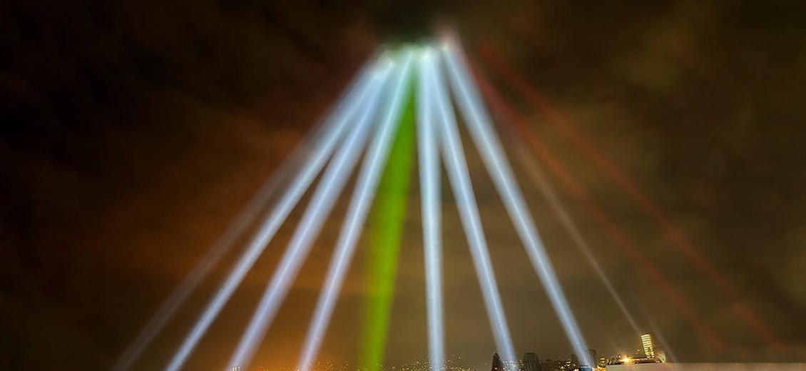 Au-dessus du port et des silos, le ciel est éclairé aux couleurs du drapeau libanais