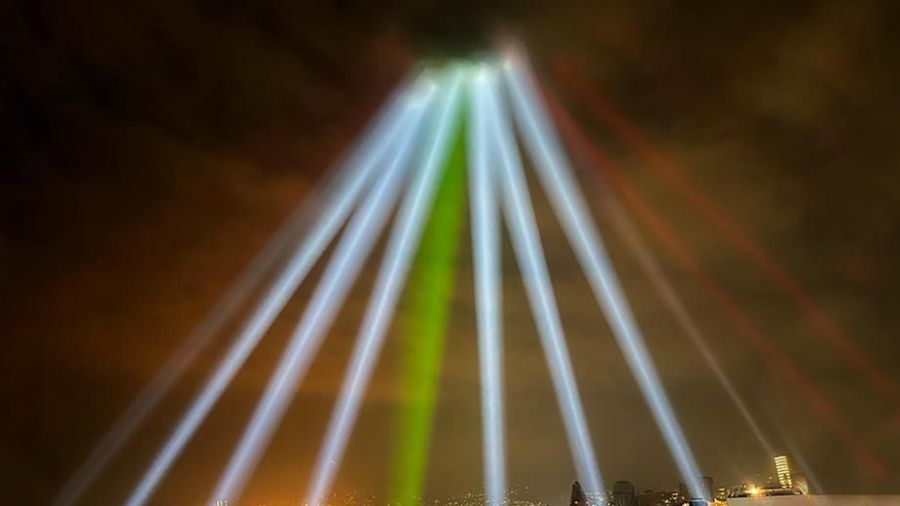 Au-dessus du port et des silos, le ciel est éclairé aux couleurs du drapeau libanais