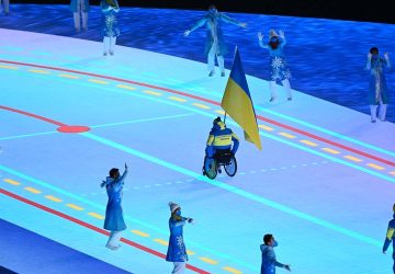 Le porte-drapeau ukrainien, Maksym Yarovyi, mène la délégation de son pays lors de la cérémonie d’ouverture des Jeux paralympiques d’hiver de Pékin. Wang/AFP